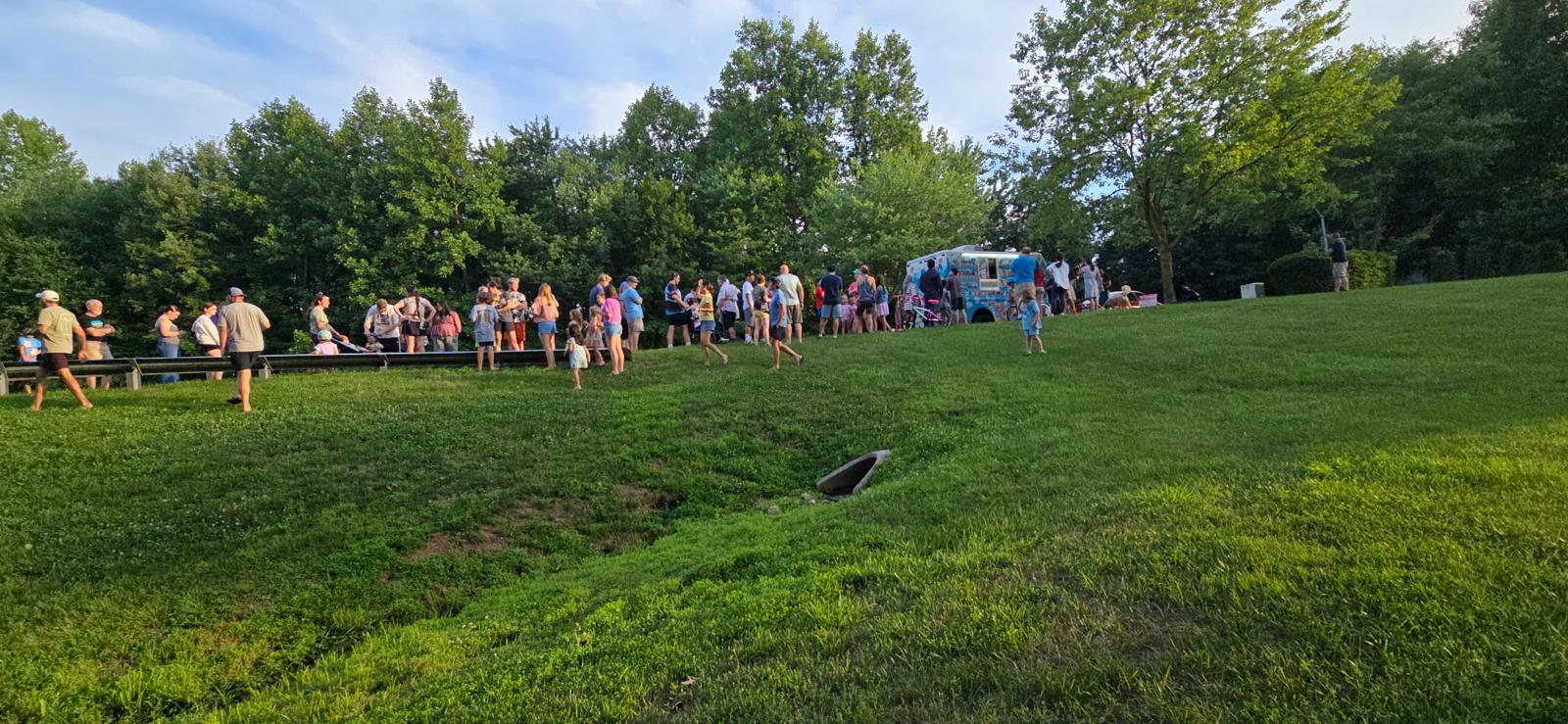Crowd of families and kids gathered around the Mr Smooth truck at a park event